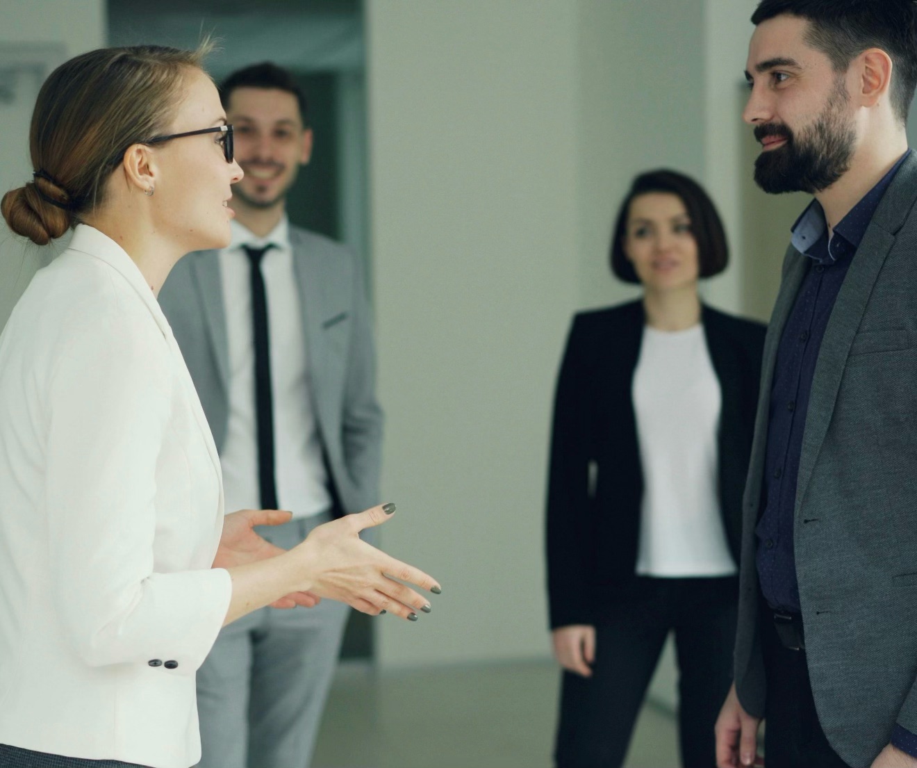 Une gestionnaire discute avec un candidat devant des collègues